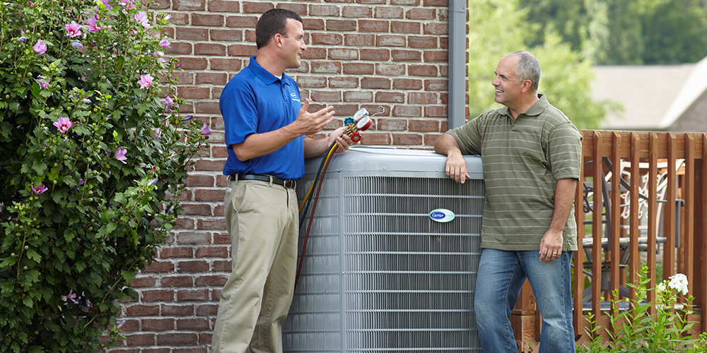 HVAC tech meets with homeowner in his backyard to install a new air conditioner.