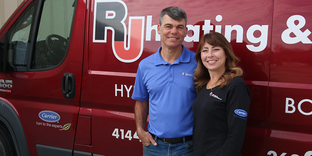 Owners Julius and Erin, creators of the Comfort First Membership program, stand by red RJ truck.