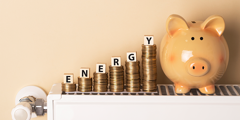 Stacks of coins next to piggy bank illustrate saved heating costs.